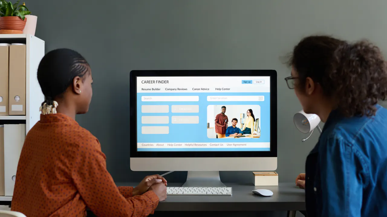 Two colleagues reviewing a website on a desktop screen, illustrating A/B testing in enterprise marketing