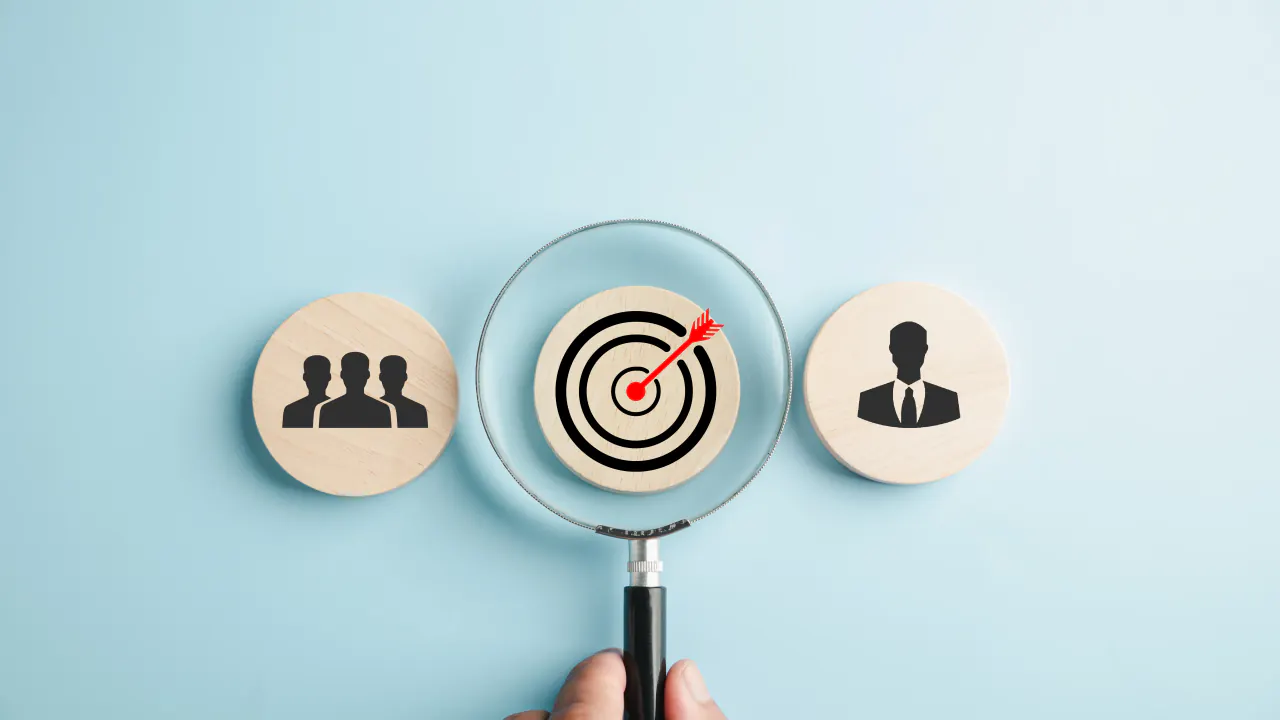 Magnifying glass over a target between customer icons, illustrating account-based marketing strategies