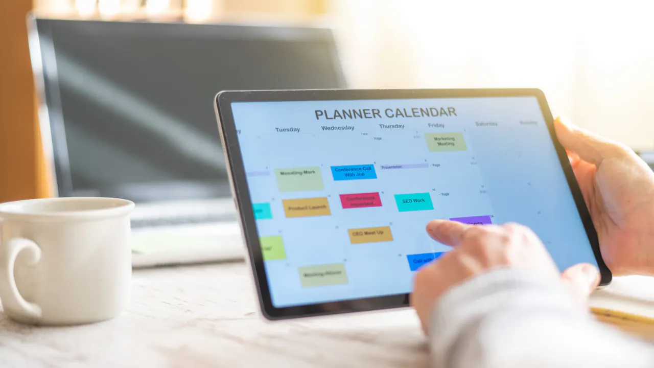 Hand scheduling on a tablet planner calendar, streamlining the business appointment setting process