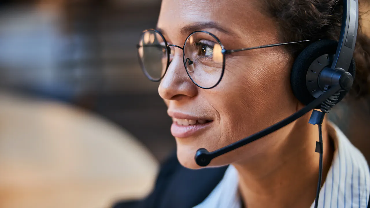 Appointment setter wearing glasses and a headset on a call, illustrating the value of appointment setters for sales success