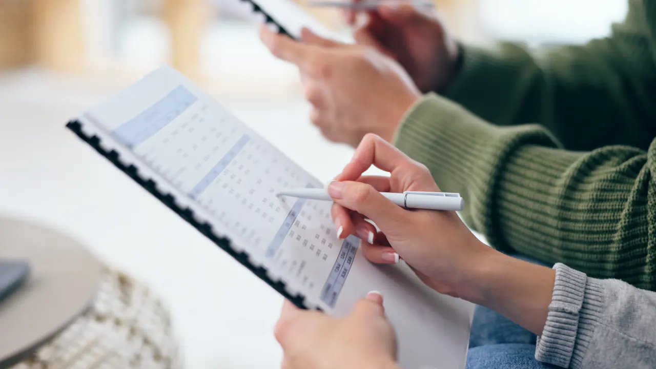 Hands marking a schedule on a planner, illustrating B2B appointment setting services