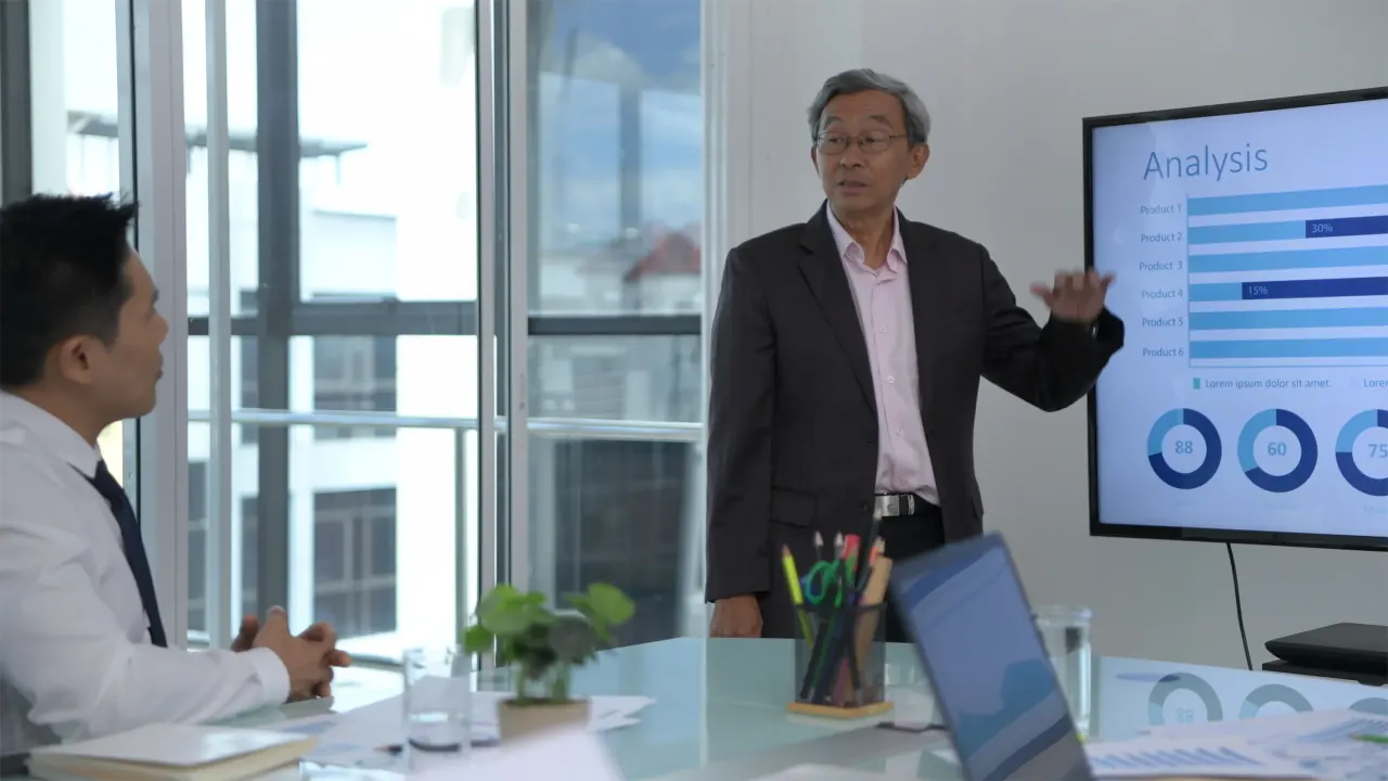 Manager presenting an analysis screen to a team, illustrating innovative B2B sales techniques