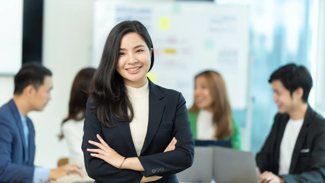 Smiling businesswoman with arms crossed in an office, representing a business development representative (BDR)