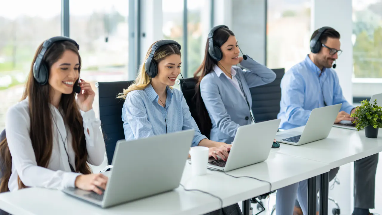Call center team in headsets working on laptops, illustrating a B2B call center