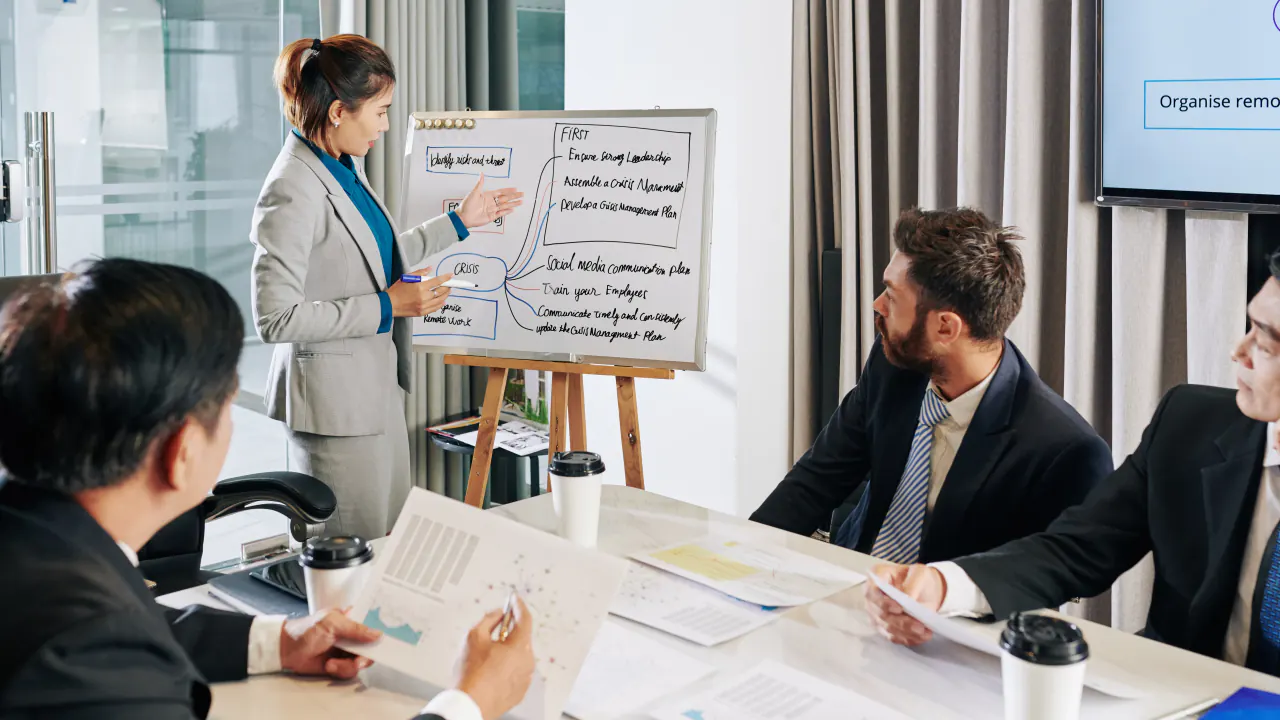 Presenter at a flip chart briefing a sales team, illustrating the Challenger Sale approach