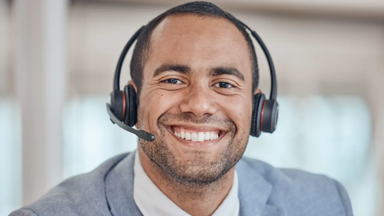 Smiling man in a headset, illustrating a friendly cold calling professional