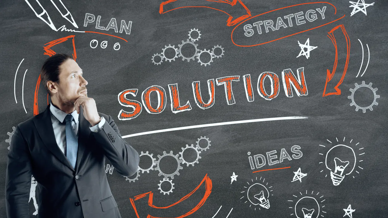 Businessman thinking in front of a chalkboard reading Solution and Strategy, illustrating conceptual selling