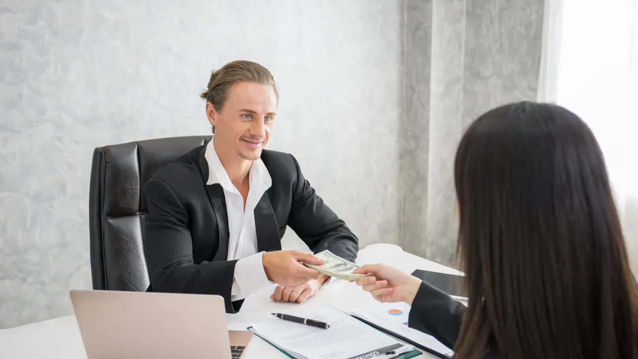 Salesperson meeting with a client at a desk, illustrating consultative selling
