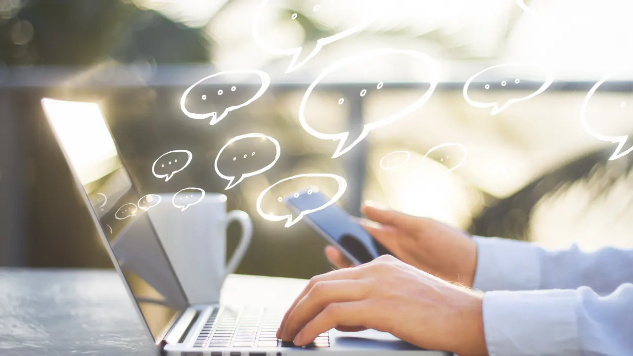 Hands on a laptop with chat bubbles floating above, illustrating conversational marketing
