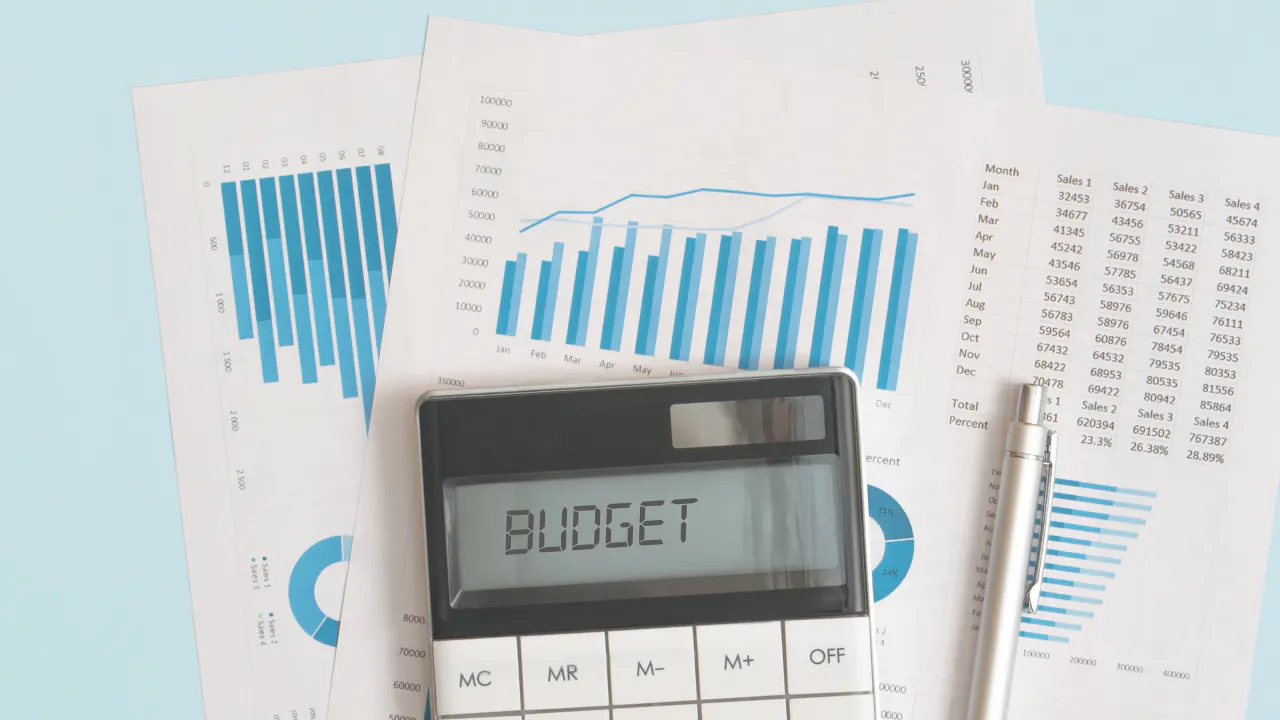 Calculator labeled Budget on printed charts, illustrating cost per lead
