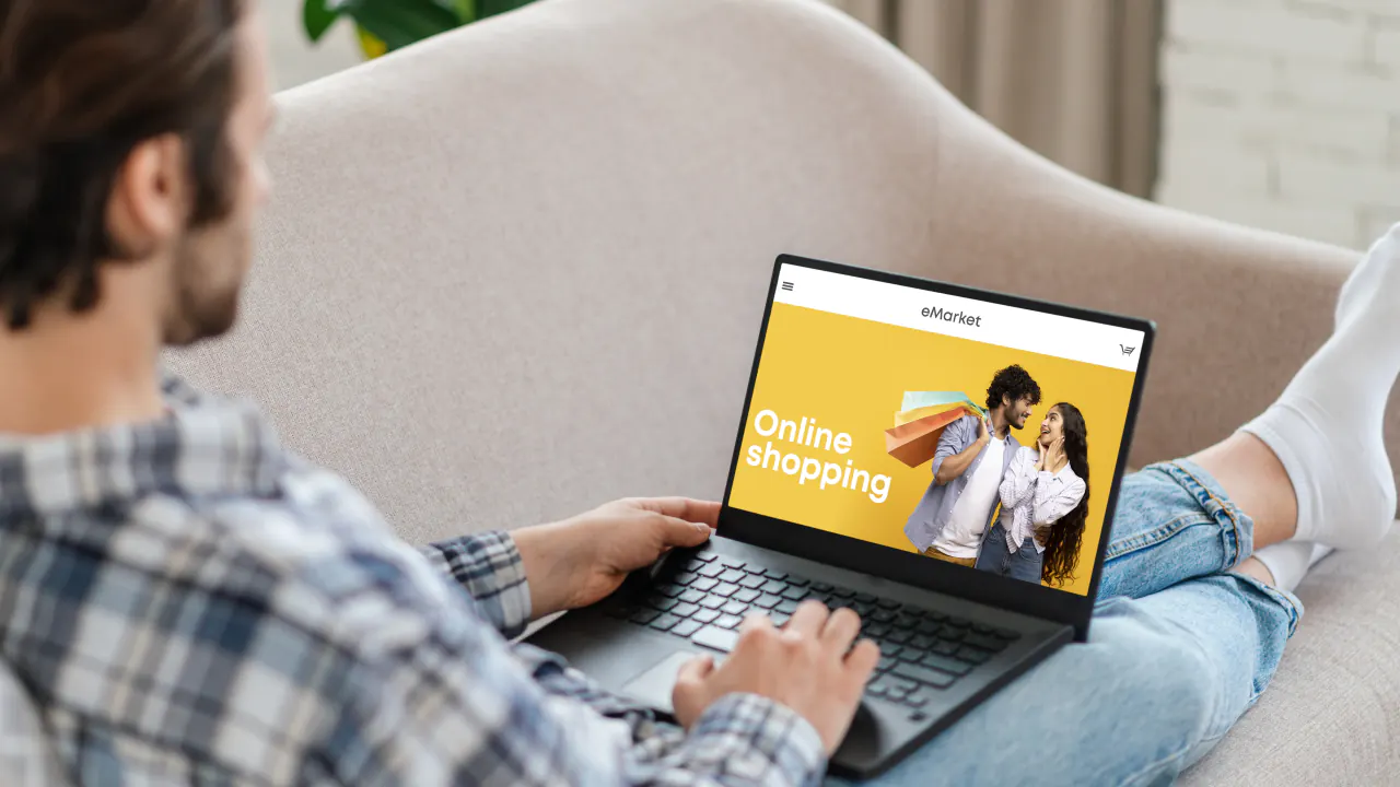 Man on a sofa browsing an online shopping site on a laptop, illustrating click-through rate (CTR)