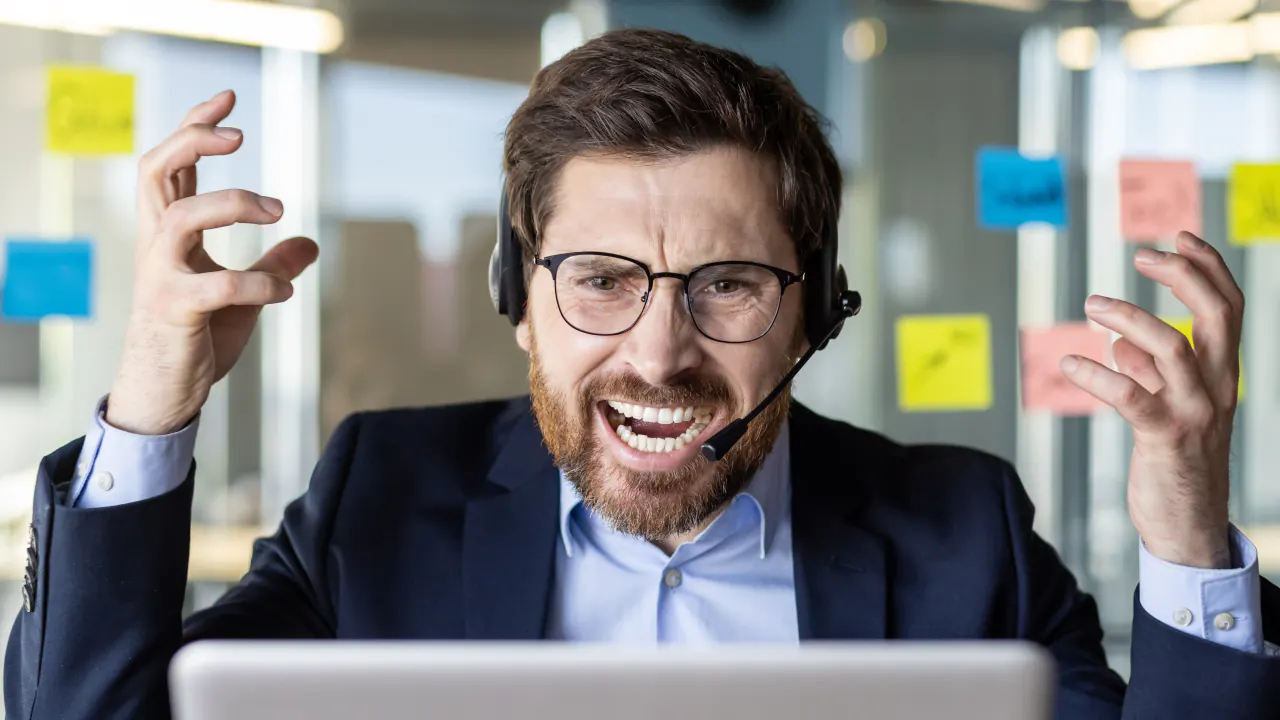 Frustrated call center rep wearing a headset, illustrating how to identify and resolve customer pain points