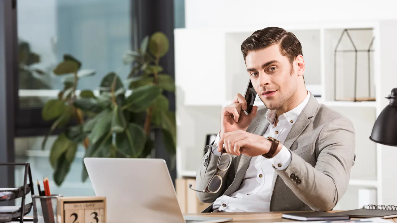 Salesman on a phone call at his desk, illustrating whether B2B cold calling still works in 2024