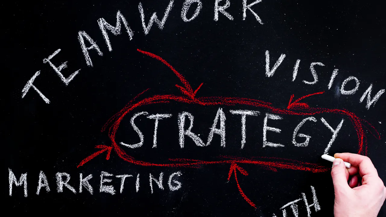 Hand writing strategy, teamwork and vision on a chalkboard for an enterprise marketing plan