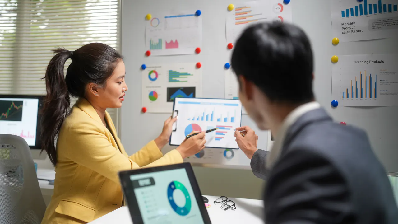 Colleagues reviewing customer data charts on a tablet, illustrating first-party data for marketing campaigns