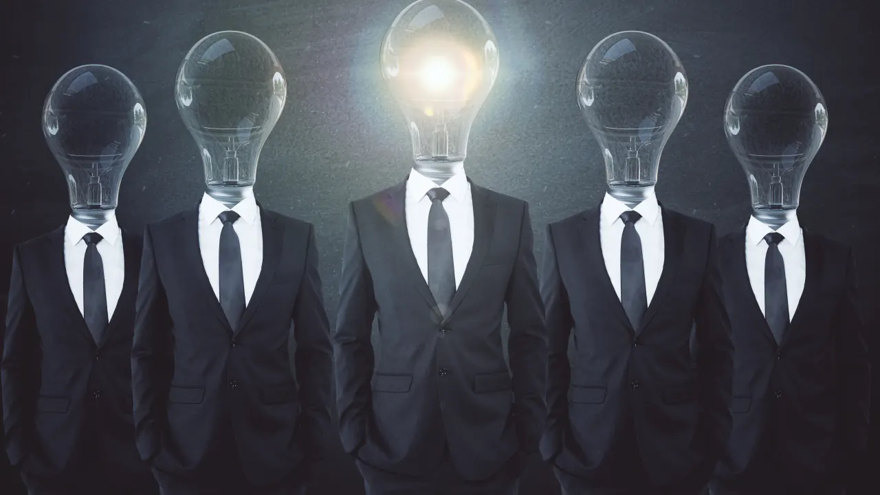 Row of businessmen with light bulb heads, one glowing, illustrating lead generation ideas