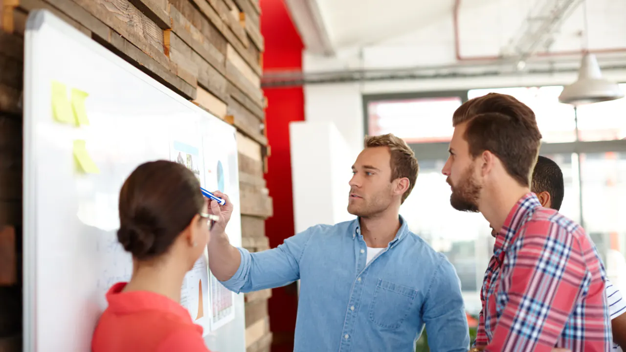 Colleagues planning at a whiteboard, illustrating GenSales awards from Clutch.co