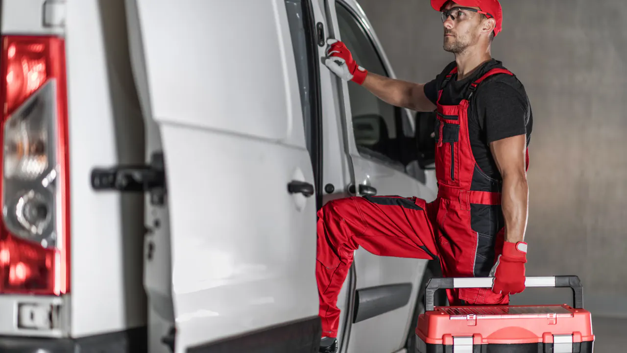 Home service technician in red overalls beside a work van, illustrating budget-friendly marketing for home service providers