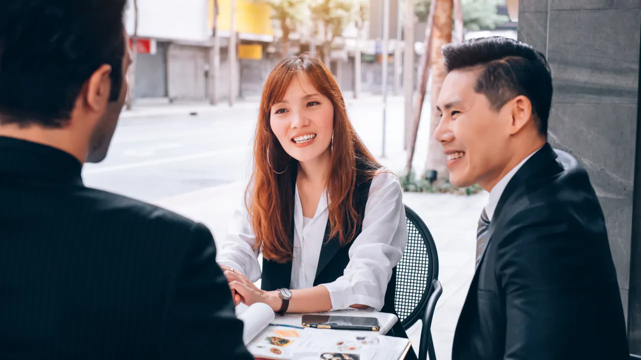 Salesperson listening to a client across a cafe table, illustrating how to respond to sales objections