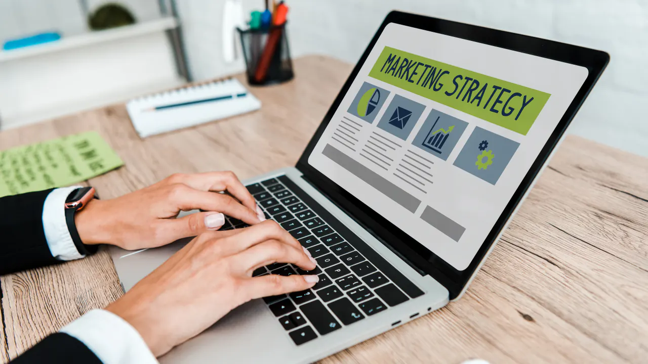 Hands typing on a laptop showing a marketing strategy page, illustrating inbound lead generation techniques