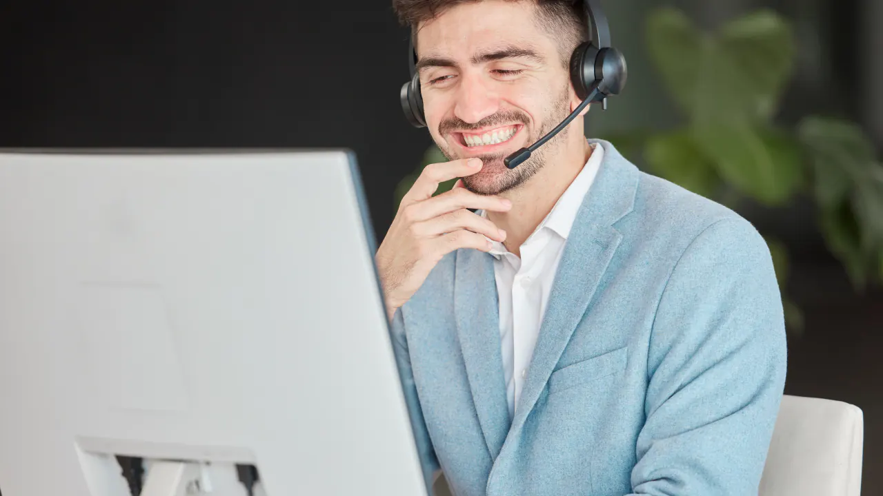 Smiling inbound sales rep with a headset at a computer, illustrating B2B inbound sales tactics