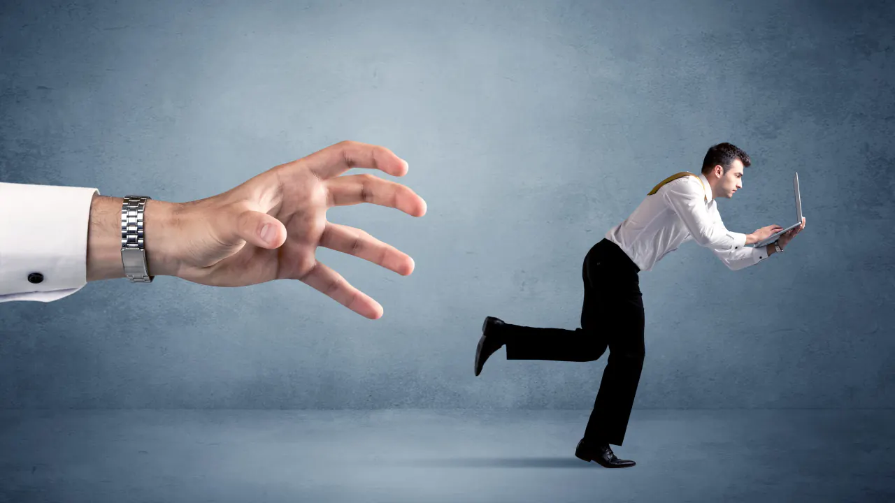 Hand reaching for a businessman running with a laptop, illustrating lead generation software vs. SDR teams