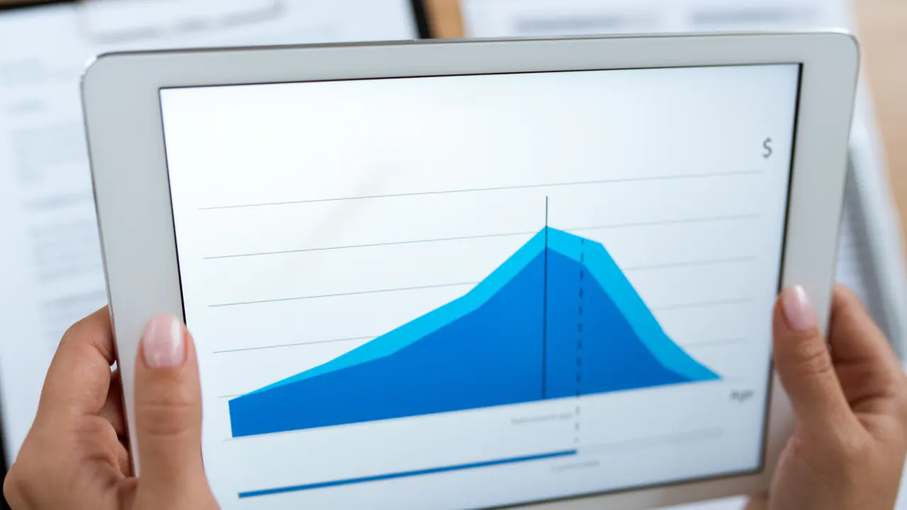 Hands holding a tablet with a blue area chart, illustrating lead scoring models