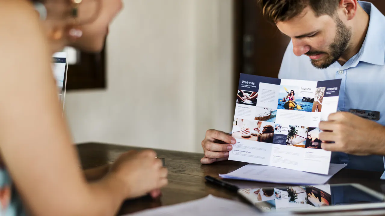 Colleagues reviewing a printed brochure at a desk, illustrating marketing collateral with targeted messaging