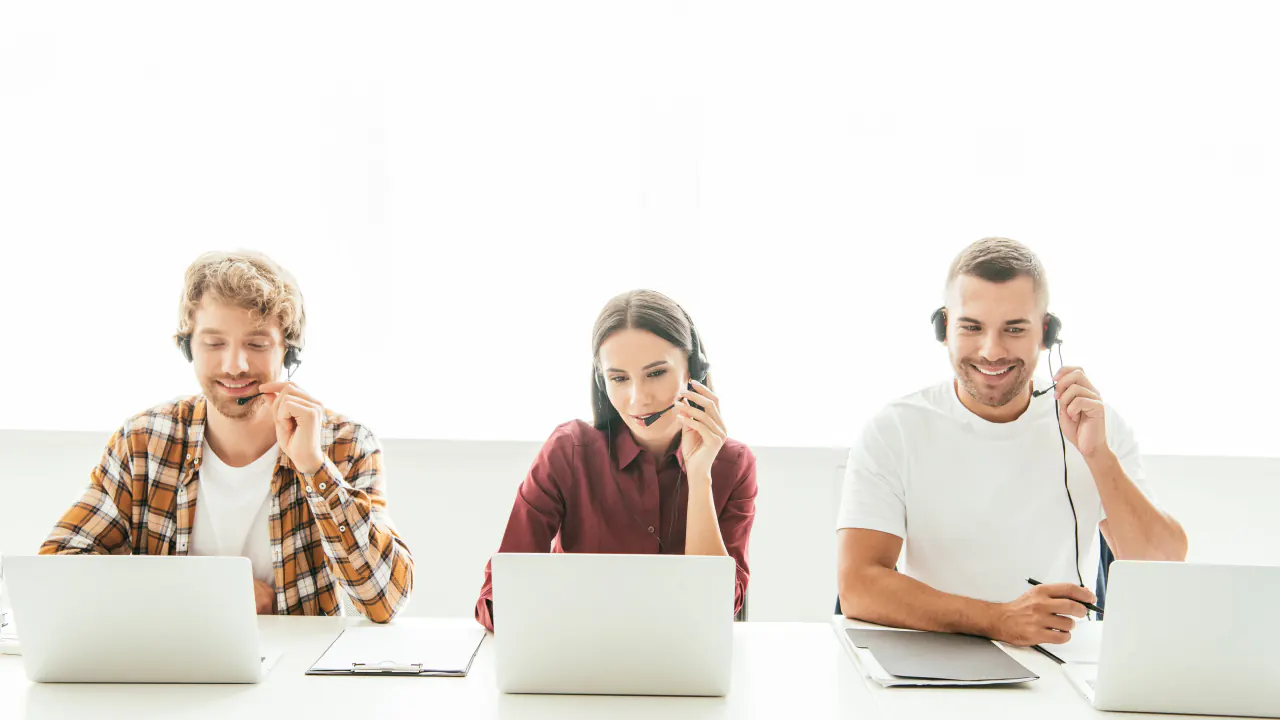 Three smiling callers with headsets at laptops, illustrating outbound lead generation strategies