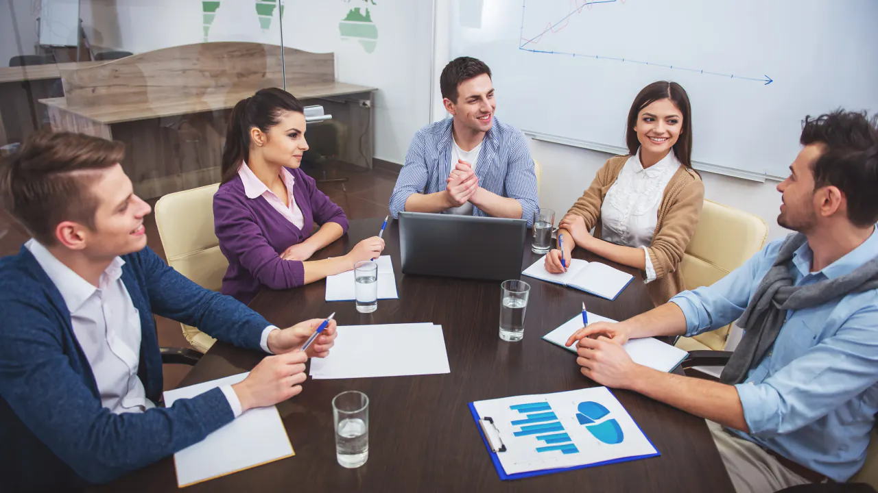 Sales team meeting around a table with reports, illustrating proven methods for generating quality sales leads