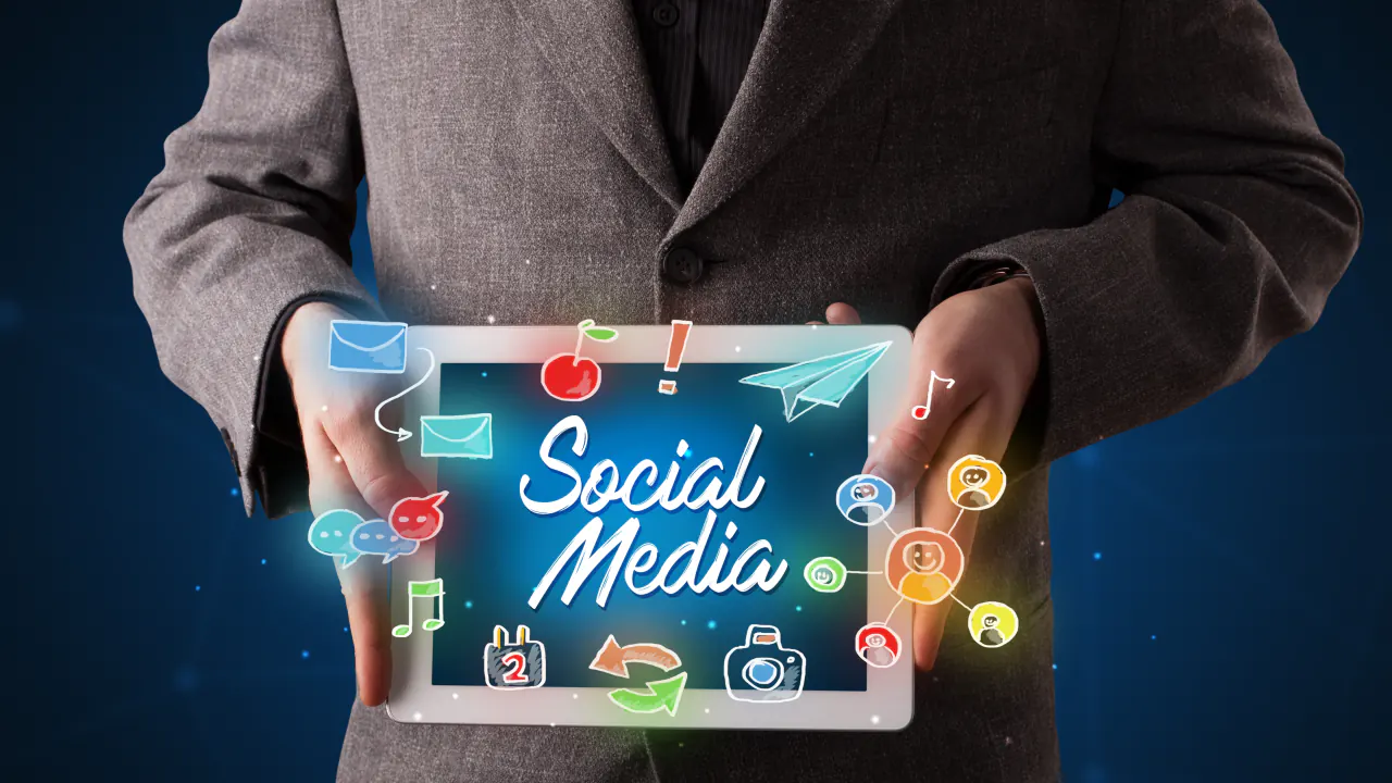 Businessman holding a tablet with social media icons, illustrating SMMA lead sourcing techniques