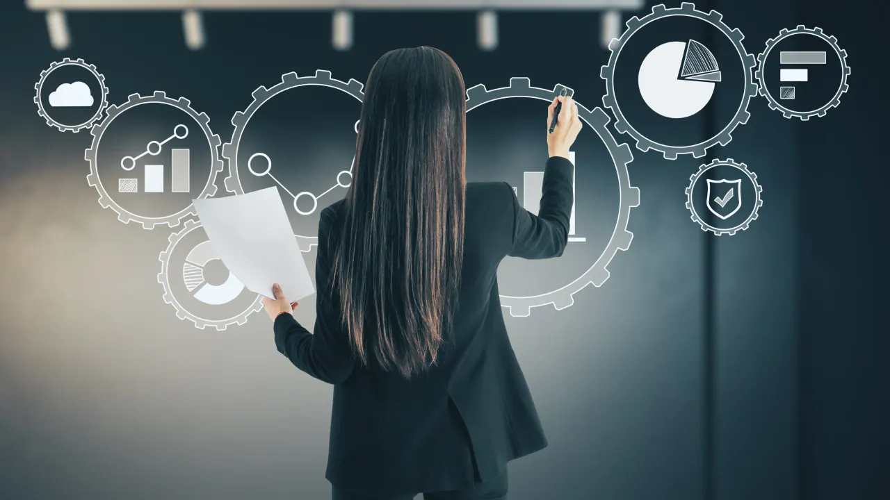 Woman drawing on a gear diagram with charts, illustrating sales process optimization