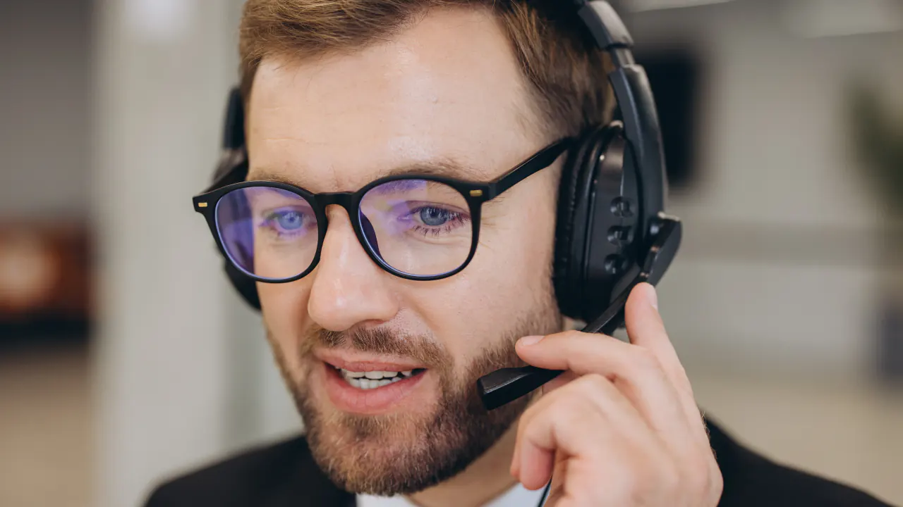 Smiling sales development representative wearing a headset on a call, illustrating the SDR role