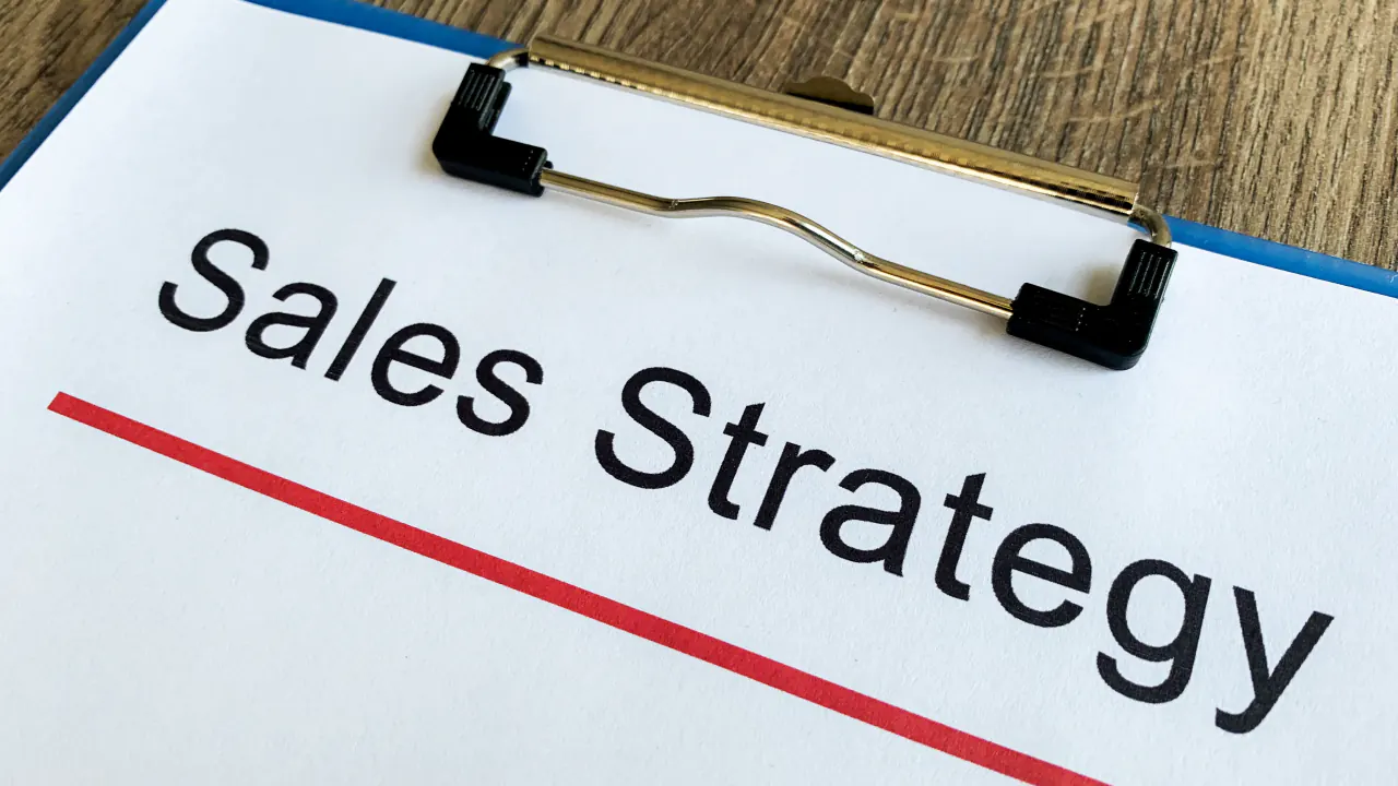 Clipboard labeled Sales Strategy, representing the SPICED sales methodology for closing more deals