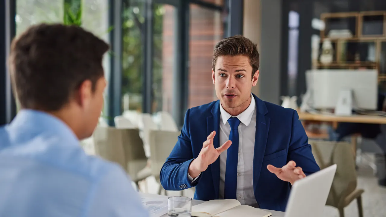 Salesperson asking a client questions in a cafe meeting, illustrating SPIN selling