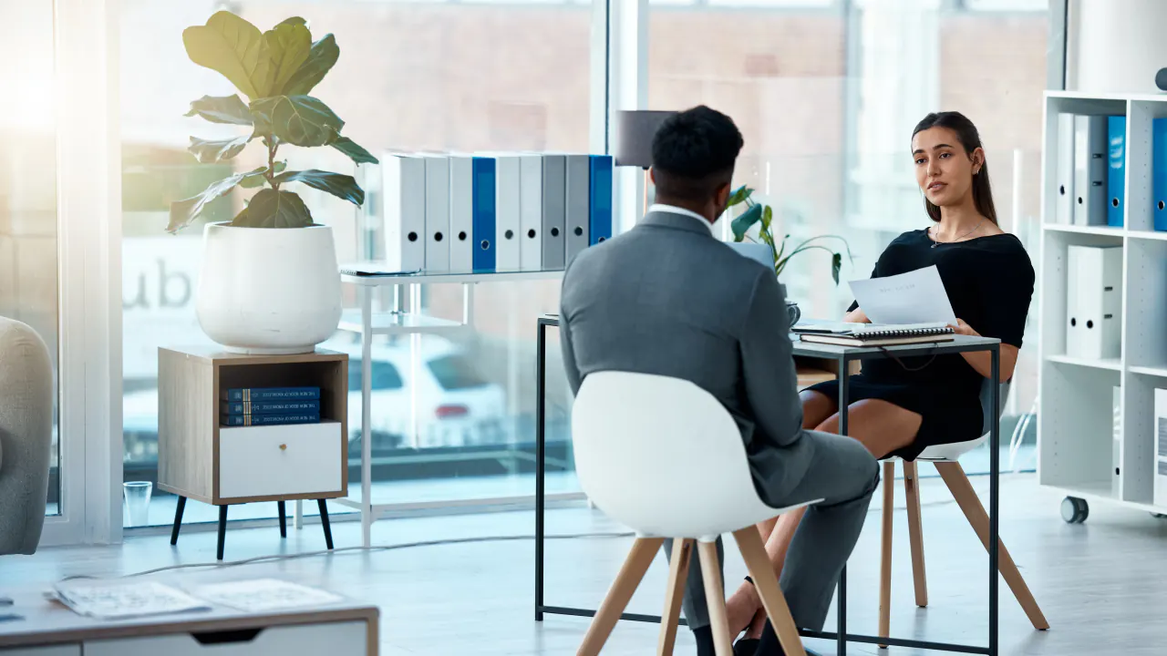 Two professionals in a bright office meeting, illustrating the benefits of B2B appointment setting