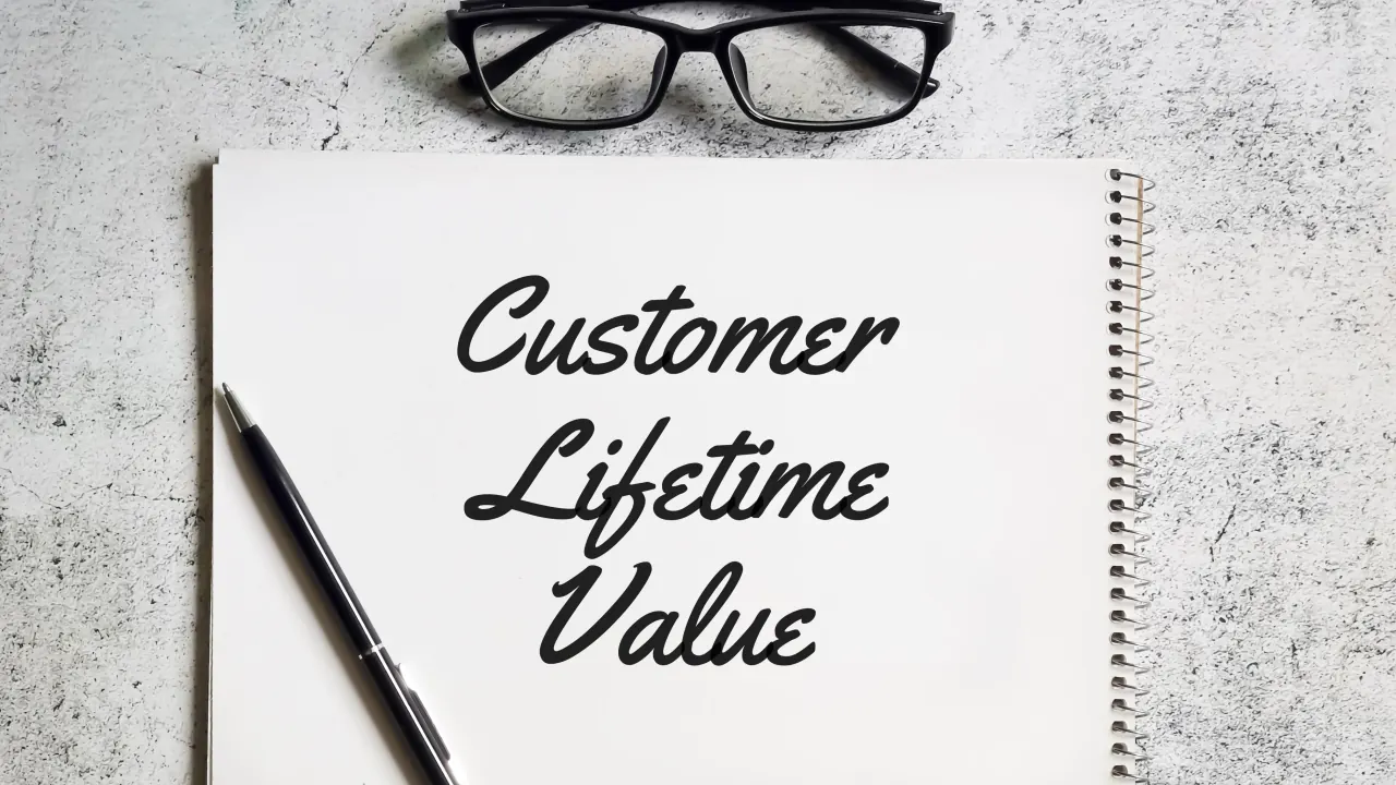 Notebook reading Customer Lifetime Value beside glasses and a pen, illustrating value based selling