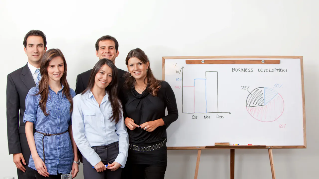 Business team smiling beside a whiteboard chart, representing modern lead generation strategies for today's businesses