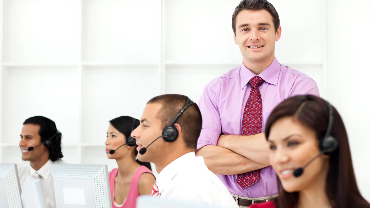 Outbound sales team wearing headsets beside their manager, illustrating outbound calling